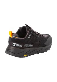 Scarpa outdoor nera con parte superiore testurizzata, punta rinforzata e suola vibram imbottita. Presenta accenti gialli e dettagli di branding.