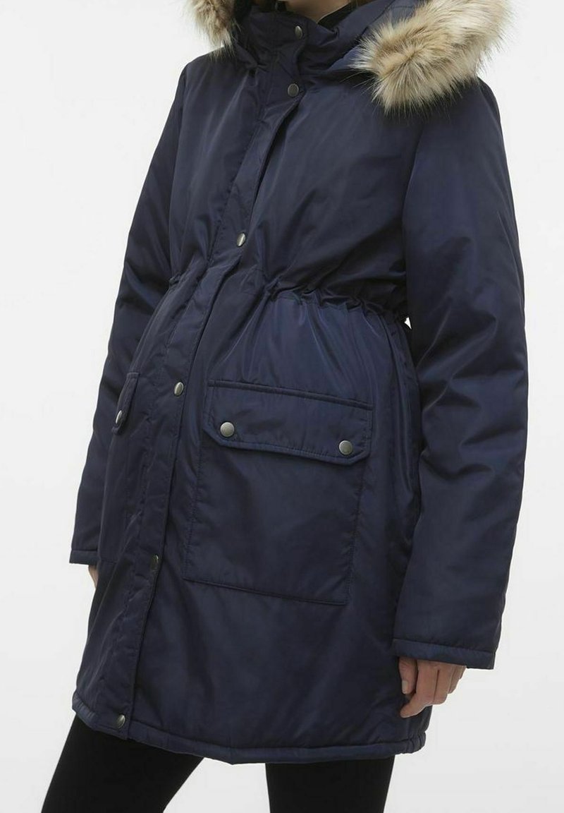 Granatowa ocieplana parka z kapturem wykończonym sztucznym futerkiem, regulowanym ściągaczem w talii oraz dwoma kieszeniami na przodzie zapinanymi na zatrzaski. Gładka faktura.