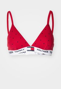 Crvena trokutasta braletica s malim crnim uzorcima srca, s tankim naramenicama i bijelim pojasom sa "Tommy Hilfiger" logotipom.