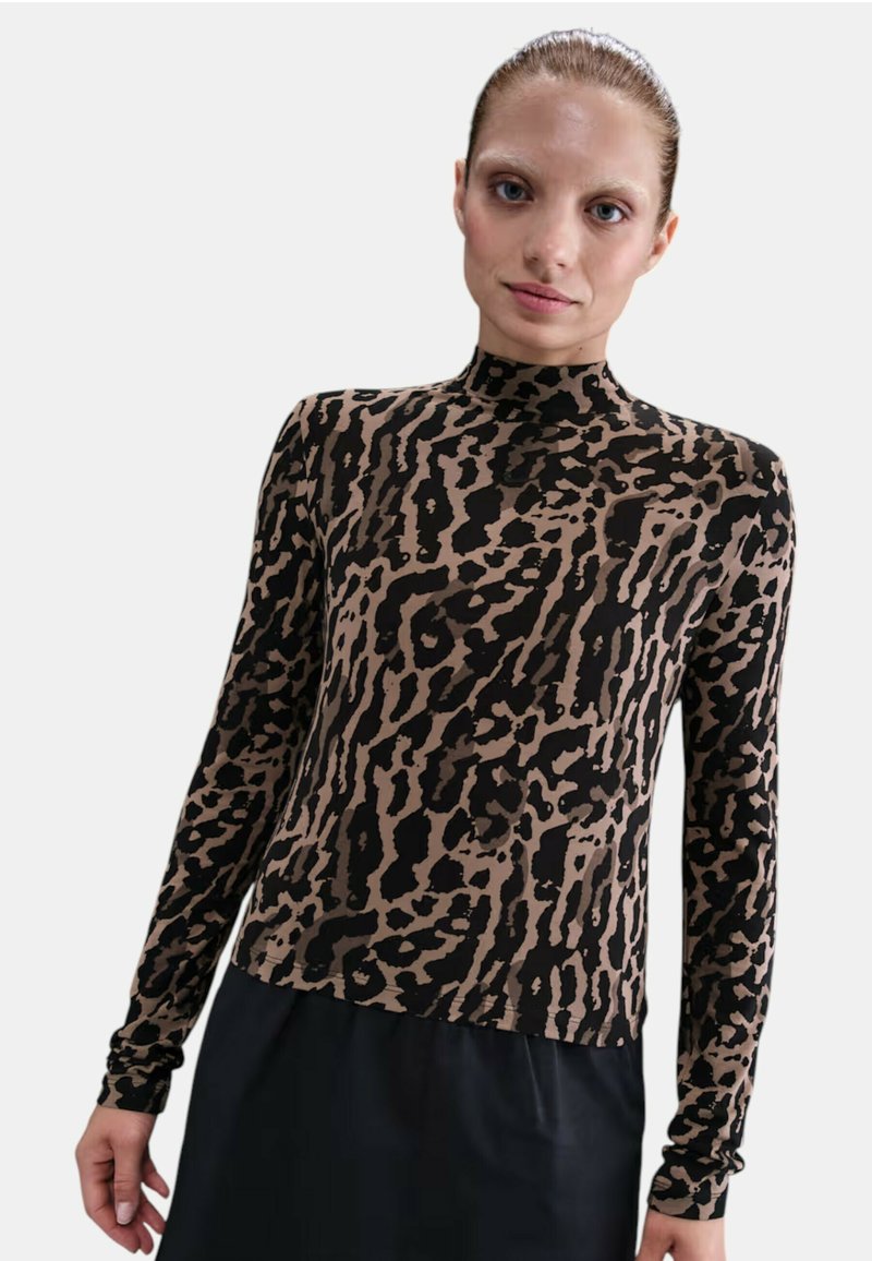 Top de manga larga con cuello alto en estampado beige y negro de animal; diseño ajustado con textura suave y cuello alto.