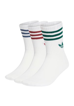 Drei Paar weiße Socken mit geripptem Bündchen, versehen mit bunten Streifen in Blau, Rot und Grün, und einem grünen Blattlogo auf einem Paar.