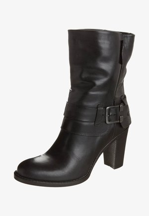 Zwarte leren midkuitlaars met een chunky hoge hak, afgeronde neus en een decoratieve band met metalen gesp rond de enkel.