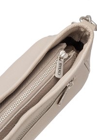 Béžová kožená kabelka s texturovaným povrchem, uzavření na horním zipu a stříbrný kovový hardware, s logem na táhle zipu.