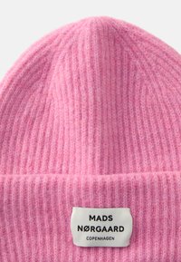 Roosa soonik, mis on valmistatud pehmest materjalist, ribakujuline, lame äärega ning sildiga, millel on musta värviga tekst "MADS NØRGAARD COPENHAGEN".