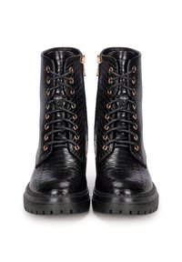 Bottes noires à cheville en matériau texturé avec un motif serpent en faux cuir, dotées de quincaillerie dorée, d'un laçage à l'avant et de fermetures éclair sur les côtés.