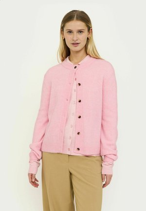Világos rózsaszín kardigán puha anyagból, kerek nyakkivágással, gombos záródással és bordázott mandzsettákkal, barna gombokkal díszítve.