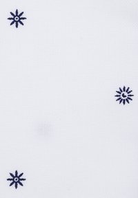 Biała tkanina z rozproszonym haftem w granatowe kwiaty. Wzór składa się z małych, gwiazdkowatych motywów z okrągłymi środkami. Tekstura wydaje się gładka.