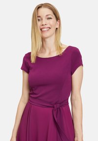 Fuchsia Kleid mit kurzen Ärmeln und Taillengürtel. Glattes Material und runder Halsausschnitt. Einfaches, elegantes Design ohne Muster.