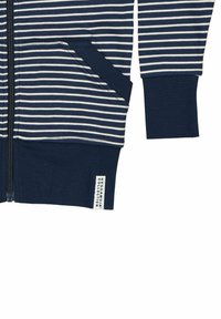 Marinstrimmig zip-up sweatjacka med vita ränder, två framfickor, ribbade ärmmuddar och en tygetikett i nederkant. Mjukt, texturerat material.