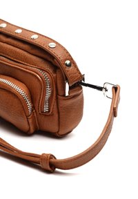 Sac en cuir marron avec plusieurs poches zippées, accents en métal argenté, finition texturée et une sangle amovible. Design compact.
