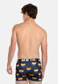 Sorte boxer shorts med et mønster af flerfarvede regnbuehjerter. Elastisk talje med "MRKO" branding. Glat materiale.