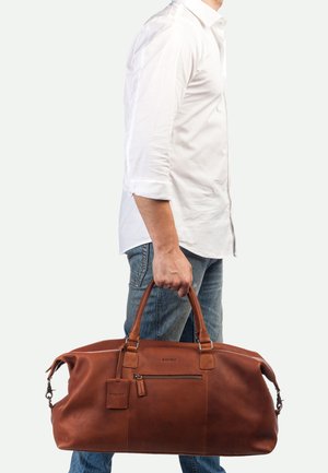 Braune Lederreisetasche mit strukturierten Oberflächen, zwei Griffen, einer Reißverschlusstasche und einem kleinen Gepäckanhänger.