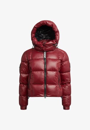 Punainen pehmustettu takki kiiltävällä pinnalla, vetoketjukiinnitys edessä ja säädettävä huppu. Varustettu elastisilla hihansuilla ja minimaalista brändäystä edessä.