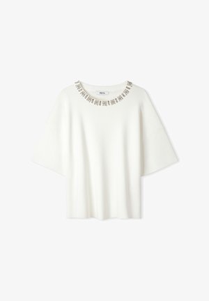 Biała bluzka z krótkim rękawem, okrągłym dekoltem, ozdobnym kołnierzykiem z delikatnymi metalicznymi akcentami oraz luźnym krojem. Miękka faktura.