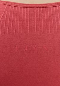 Czerwony top z elastycznej tkaniny, o prążkowanej fakturze i wplecionym logo z przodu. Bezszwowy dekolt zapewniający gładkie wykończenie.