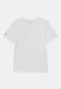 Simpel hvid T-shirt med korte ærmer set fra bagsiden, med et lille sort logo på venstre ærme.