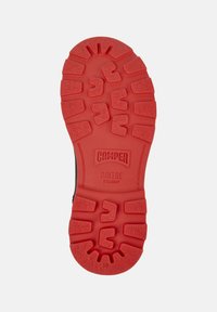 Sole di scarpa in gomma rossa con scanalature profonde, marchio Camper, testo "BRIDGE XTRAGRIP" e numero di taglia 38 visibile sul fondo.