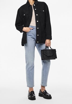 Chaqueta de mezclilla negra con botones plateados, camiseta a rayas, jeans rectos de color azul claro y bolso negro texturizado. Mocasines negros gruesos.