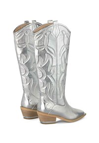 Botas de vaquero metálicas plateadas con costuras decorativas, puntera puntiaguda y tacón bajo apilado. Presenta espirales grabadas y un acabado texturizado.