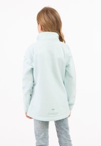 Giacca leggera blu cielo resistente alle intemperie con colletto alto e orlo leggermente curvo, caratterizzata da un semplice logo sul retro.