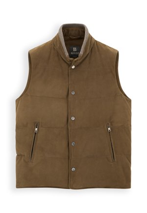 Homme portant un gilet marron, un pull beige, une casquette plate et un pantalon foncé, tenant un grand sac de voyage gris et des gants marron sur fond blanc.