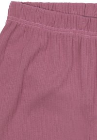 Roze ribstof met een gestructureerd oppervlak; heeft een elastische tailleband met zichtbare stikdetails. Zacht en flexibel materiaal.