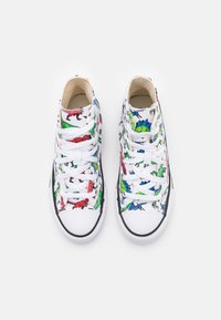 Bílé plátěné tenisky s živým potiskem dinosaurů v červené, zelené a modré barvě. Klasický zavazovací design s černými gumovými akcenty.