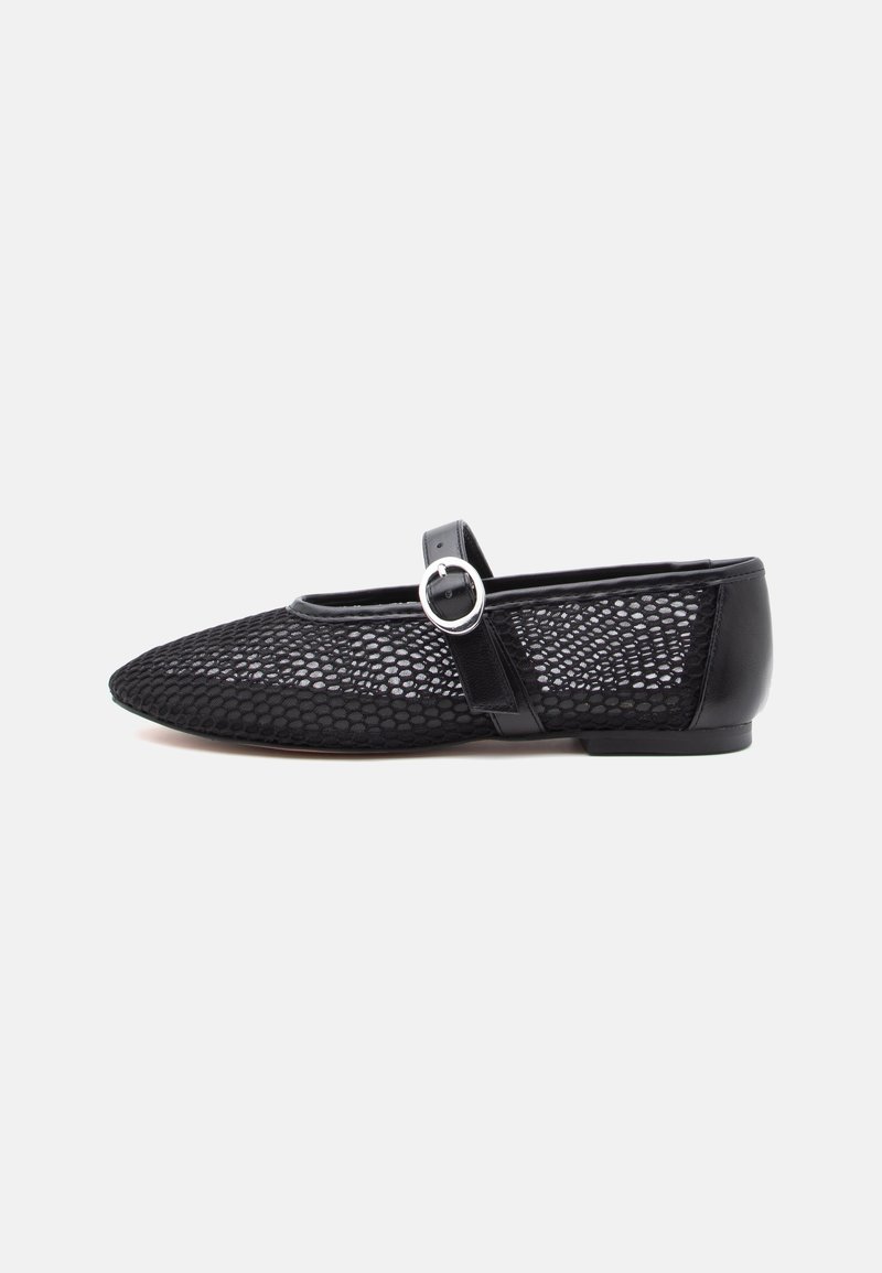 Chaussure plate noire avec un bout pointu, tige en mesh et une bride en cuir avec une boucle argentée sur le dessus.