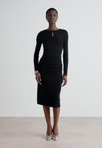 Black long-sleeve dress with a fitted silhouette, soft texture, a round neckline featuring a keyhole detail, and gathered accents.