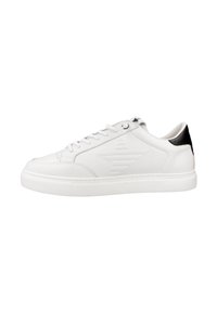Zapatilla de cuero blanca con un acabado liso, que presenta un acento negro en el talón, punta redondeada y detalle de logotipo texturizado en el costado. Suela de goma.