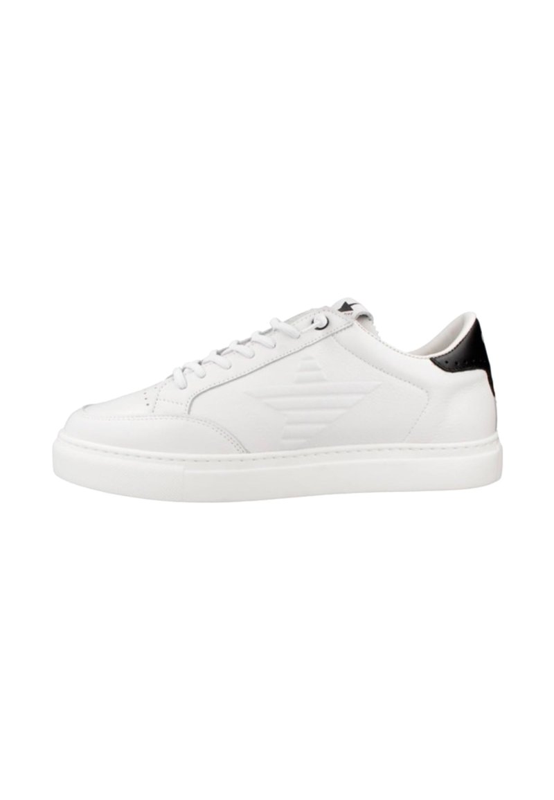 Zapatilla de cuero blanca con un acabado liso, que presenta un acento negro en el talón, punta redondeada y detalle de logotipo texturizado en el costado. Suela de goma.