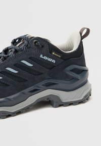 Tumši zili pārgājienu apavi ar teksturētu virsu, ar pelēkiem akcentiem, mīkstu papēdi un izturīgu zoli. Redzama ūdensizturīga GORE-TEX zīmola. 