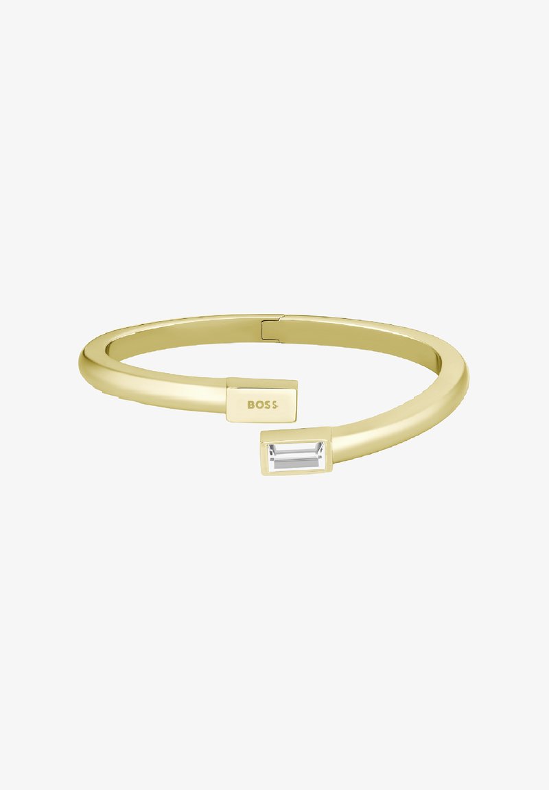 Pulsera de bangle en tono dorado con un diseño sleek y redondeado. Presenta un acento de piedra clara rectangular y un detalle grabado con el logo "BOSS".