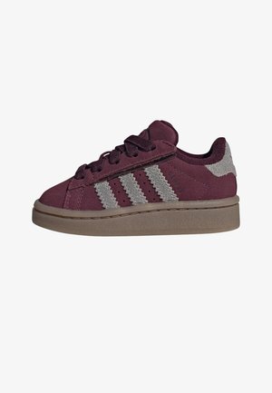 Zamszowy, bordowy sneaker dla dzieci z beżową podeszwą, trzema beżowymi paskami po bokach i pasującymi bordowymi sznurowadłami.