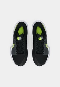 Μαύρα αθλητικά παπούτσια με γκρι λεπτομέρειες, φωσφοριζέ πράσινη εσωτερική επένδυση, υφές στην επιφάνεια και λευκές σόλες; διαθέτουν κορδόνια και λεπτομέρειες με λογότυπο.