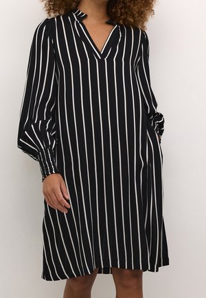 Robe rayée noire et blanche avec un col en V et de longues manches ballon, fabriquée en tissu doux avec une coupe décontractée et sans motifs apparents.
