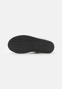 Talpa de cauciuc neagră cu un model texturat în zigzag și logo embosat. Are un material superior neted, de culoare deschisă.