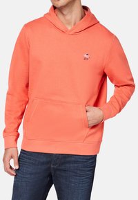 Koraleowy sweatshirt z kapturem wykonany z miękkiego materiału, z przednią kieszenią i małym logo na klatce piersiowej. Klasyczny krój i ściągacze przy rękawach.
