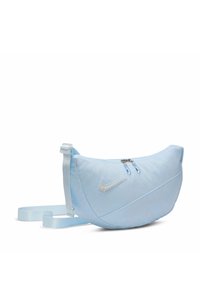 Svijetloplavi Nike fanny pack, mekan materijal, zakrivljen oblik, zatvaranje na rajsferšlus, podesiva traka i logo s bisernim naglascima sprijeda.