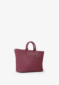 Sac fourre-tout en cuir bordeaux avec deux poignées supérieures, design simple et texture lisse. Il dispose d'une fermeture éclair et n'a pas de motifs visibles.