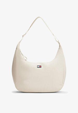 Kremowa torba hobo z nylonu o zaokrąglonym kształcie, z pojedynczym paskiem na ramię oraz naszywką z logo w kolorach czerwonym, białym i niebieskim.