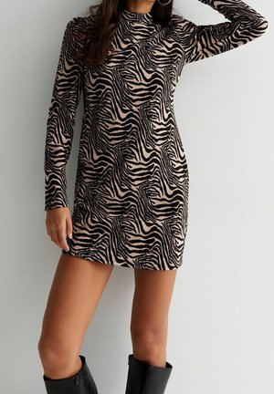 Robe zèbre à manches longues en beige et noir, avec un col haut et une silhouette ajustée. Tissu doux et texturé, longueur au-dessus des cuisses.