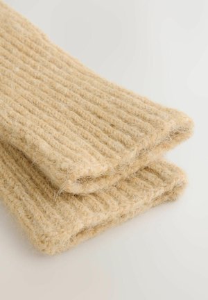 Material tricotat din lână cu nervuri, de culoare bej deschis, având o suprafață texturată și un aspect ușor pufoasă, pliată cu grij ă.