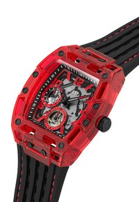 Reloj de plástico transparente rojo con correa de goma negra, que presenta dos subesferas, marcadores numéricos en negrita y acentos negros contrastantes.
