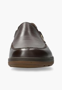 Brown leather slip-on shoe with a smooth texture, rounded toe, stitched detailing, and a rubber sole. Features a side elastic for ease of wear.