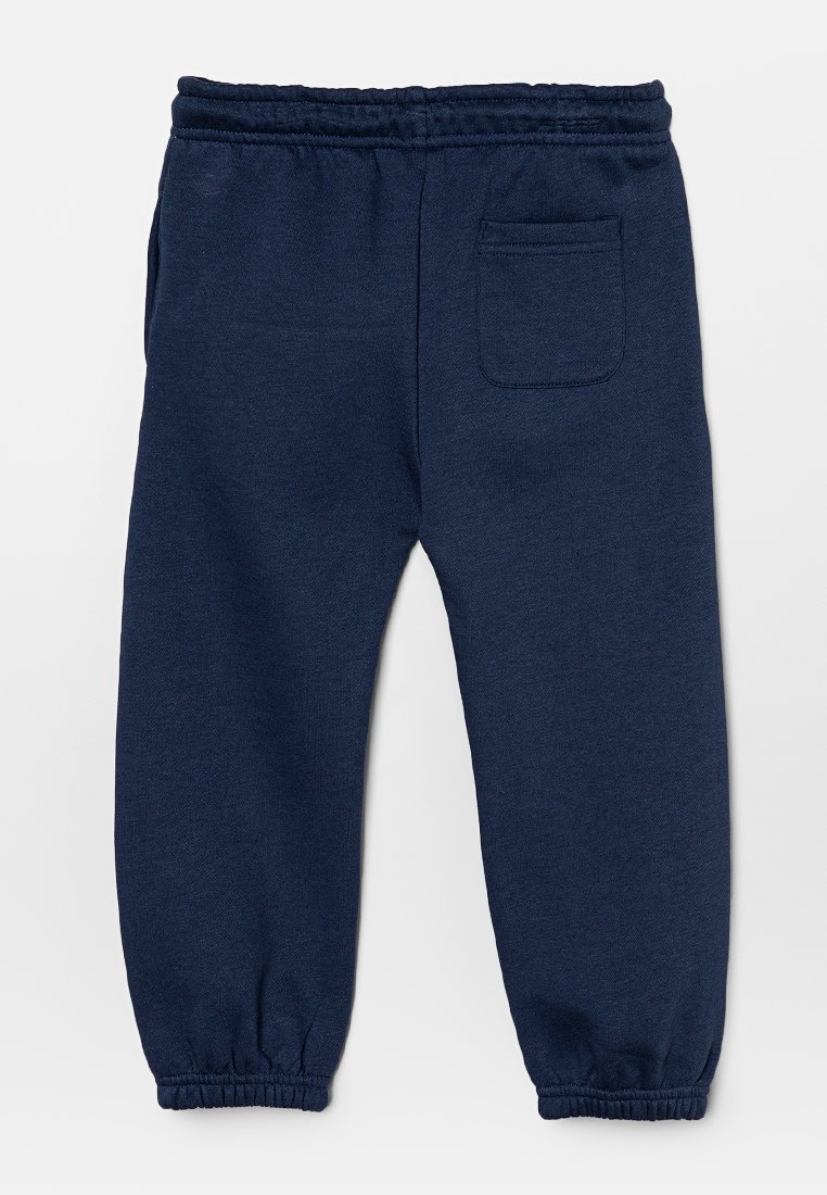 Pantalons de survêtement bleu marine en tissu doux, dotés d'une taille élastique et de poignets élastiques, avec une poche arrière pour un détail supplémentaire.