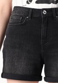 Shorts in denim nero con vita alta, orli arrotolati, design a cinque tasche e chiusura con bottone metallico, caratterizzati da una leggera scoloritura.