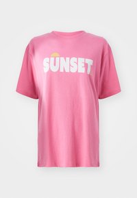 Krátký růžový tričko vyrobené z bavlny, s výrazným bílým textem "SUNSET" a grafikou žlutého slunce. Kulatý výstřih a krátké rukávy.