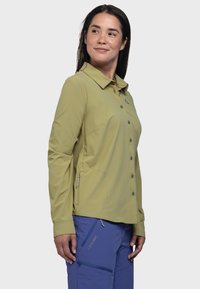 Hellgrünes Langarmhemd mit Kragen, vorderen Taschen und einem kleinen Logo auf der Brust. Glatte Textur, lässige Passform.