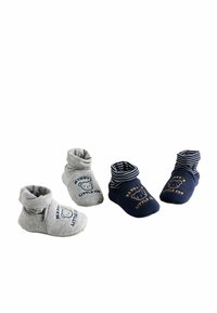 Två par babybooties: en grå med rullad mudd och björngrafik, den andra marinblå med ränder och texten "Daddy's Little Cub".